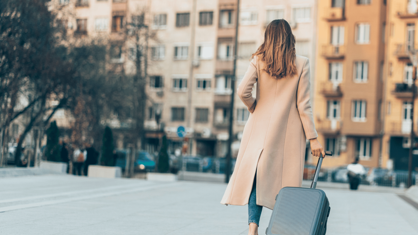 Woman walking with suitcase thorough courtyard in Europe. European Travel. Europe Travel. Travel in Europe. Womens Travel luggage.